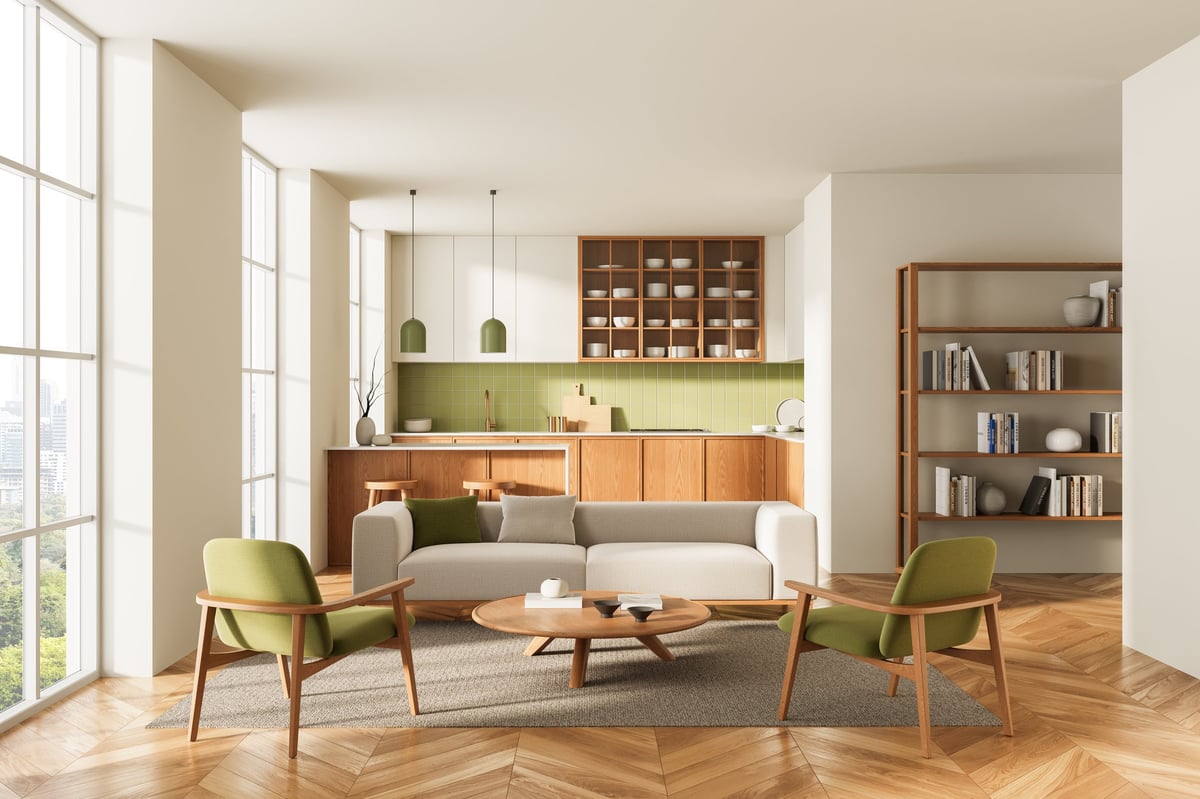 Open-plan living room and kitchen with green chairs, wood accents, and soft sunlight, minimalist Scandinavian concept on neutral background, 3D Rendering