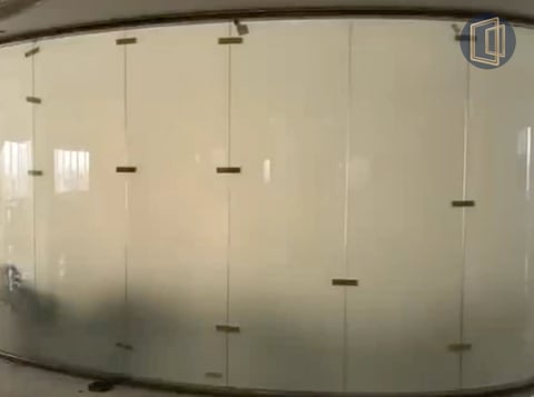 Frosted glass bathroom enclosure with metal handles and hardware mounted on white tiled wall
