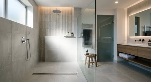 Modern bathroom with walk-in shower, floating vanity, mirror with lighting, and minimalist design in neutral tones